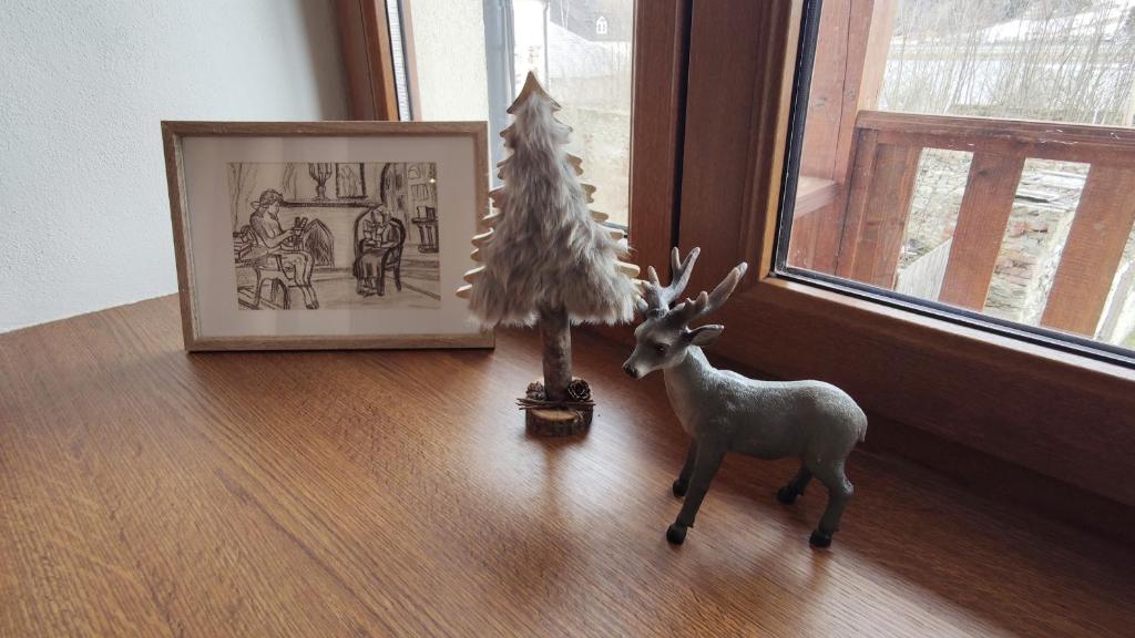 a figurine of a deer on a table next to a picture at Mala Narnia in Frymburk