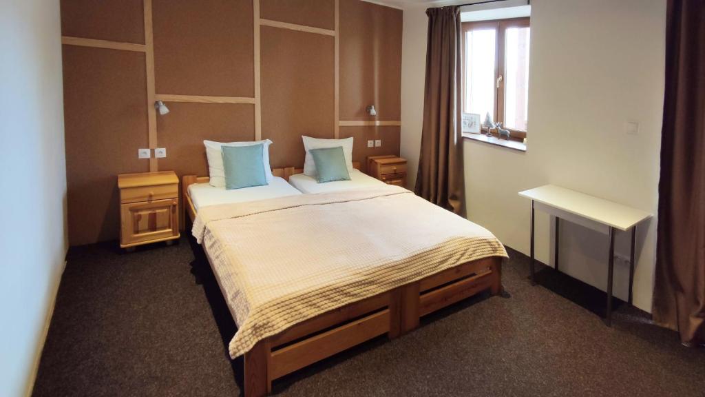 a hotel room with a large bed with blue pillows at Mala Narnia in Frymburk