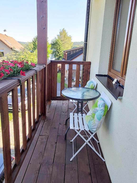 a table and two chairs on a balcony at Mala Narnia in Frymburk