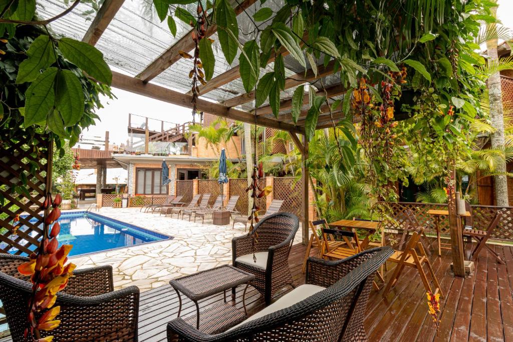 an outdoor patio with chairs and a swimming pool at Pousada Descanso do Rei in Praia do Rosa