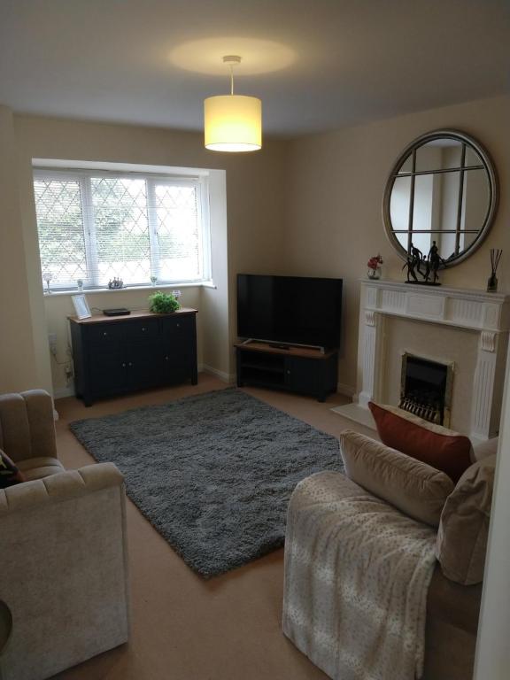 a living room with a couch and a fireplace at Sunningdale homely detached family/contractor 3 bed house in Lincolnshire