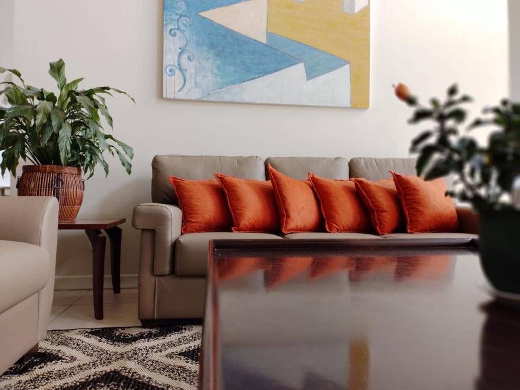sala de estar con sofá y almohadas de color naranja en Harbor Self Graciosa Hotel, en Quatro Barras