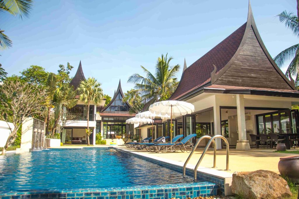 a resort with a swimming pool in front of a building at Baan Chom Tawan Villa in Lipa Noi