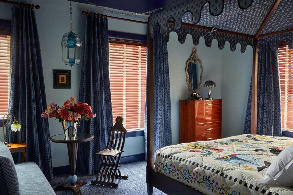 een slaapkamer met een hemelbed en een tafel en stoelen bij Ulysses in Baltimore