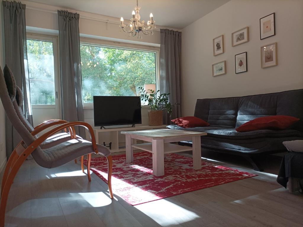 a living room with a couch and a table at Ihan Puotilan Metron lähellä in Helsinki