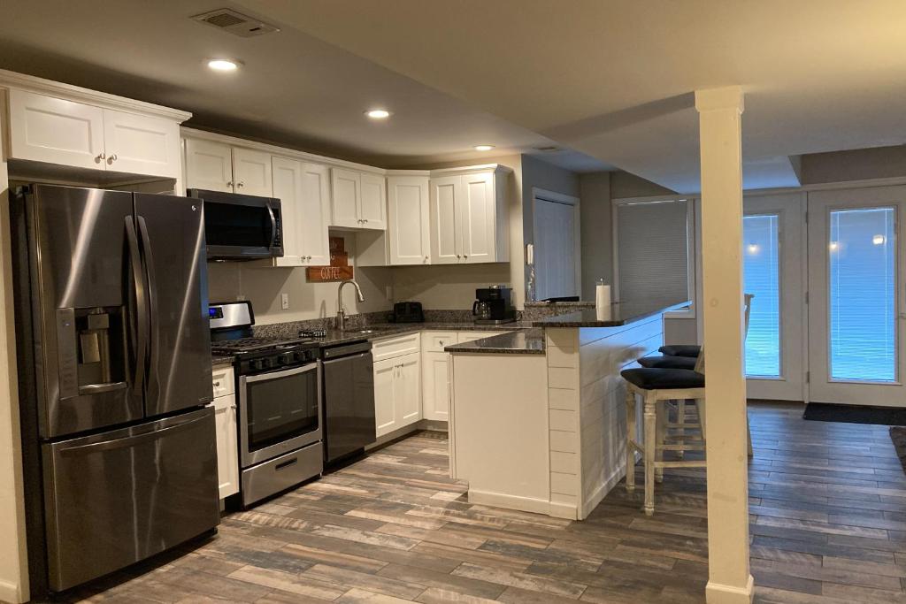 a kitchen with white cabinets and a stainless steel refrigerator at Leisure Lake in Oakland
