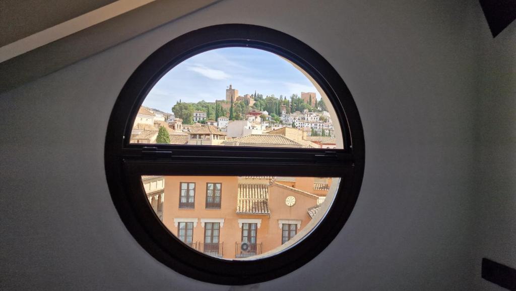 a round window with a view of a city at Imeda Apartamentos Escudo del Carmen 19 in Granada