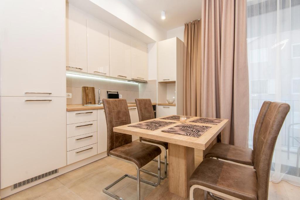 a kitchen with a table and chairs and a refrigerator at Apartment Odysseus in Tivat