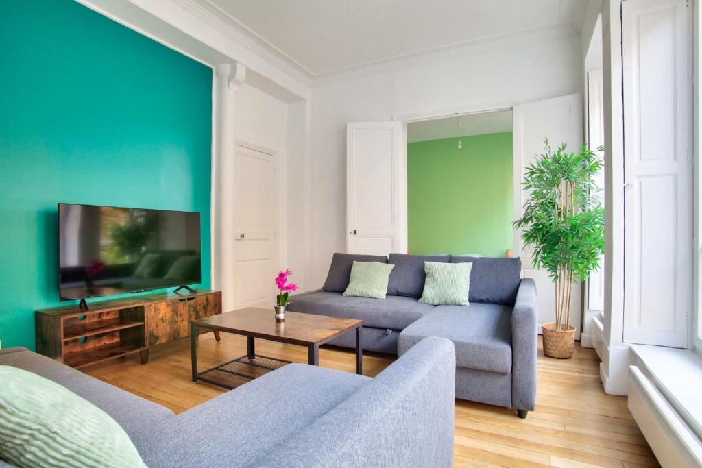 uma sala de estar com um sofá e uma televisão em Appartement Quartier Chatelet Les Halles em Paris