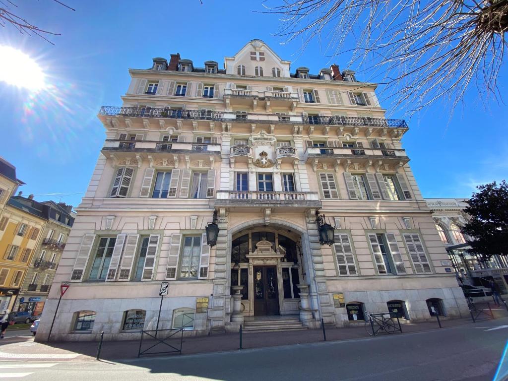 een groot stenen gebouw met een klok aan de voorkant bij Location dans le Grand Hotel d'Aix les bains in Aix-les-Bains