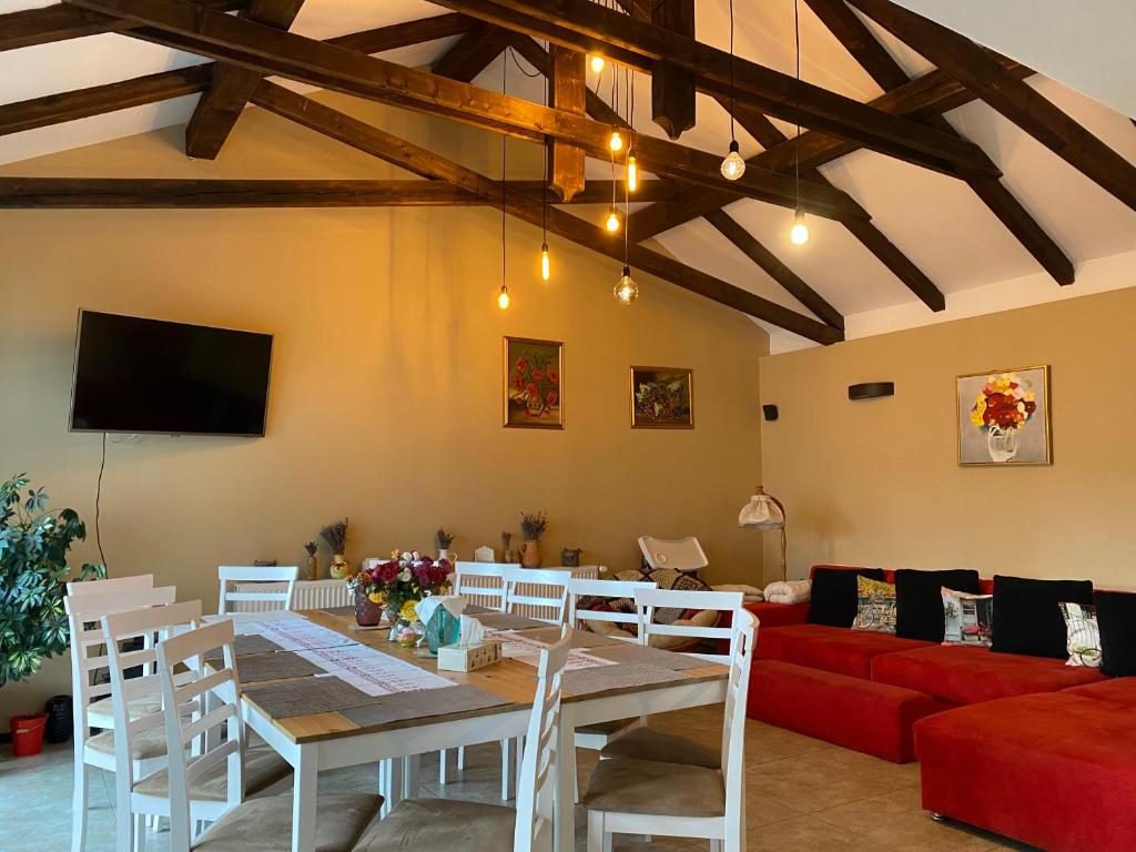 a living room with a table and a red couch at Agropensiunea Colev in Stremţ