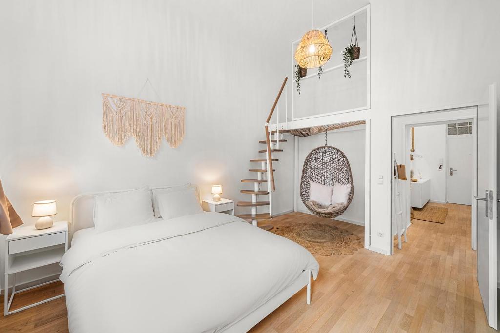 a white bedroom with a bed and a staircase at The BoHo Loft VIE in Vienna
