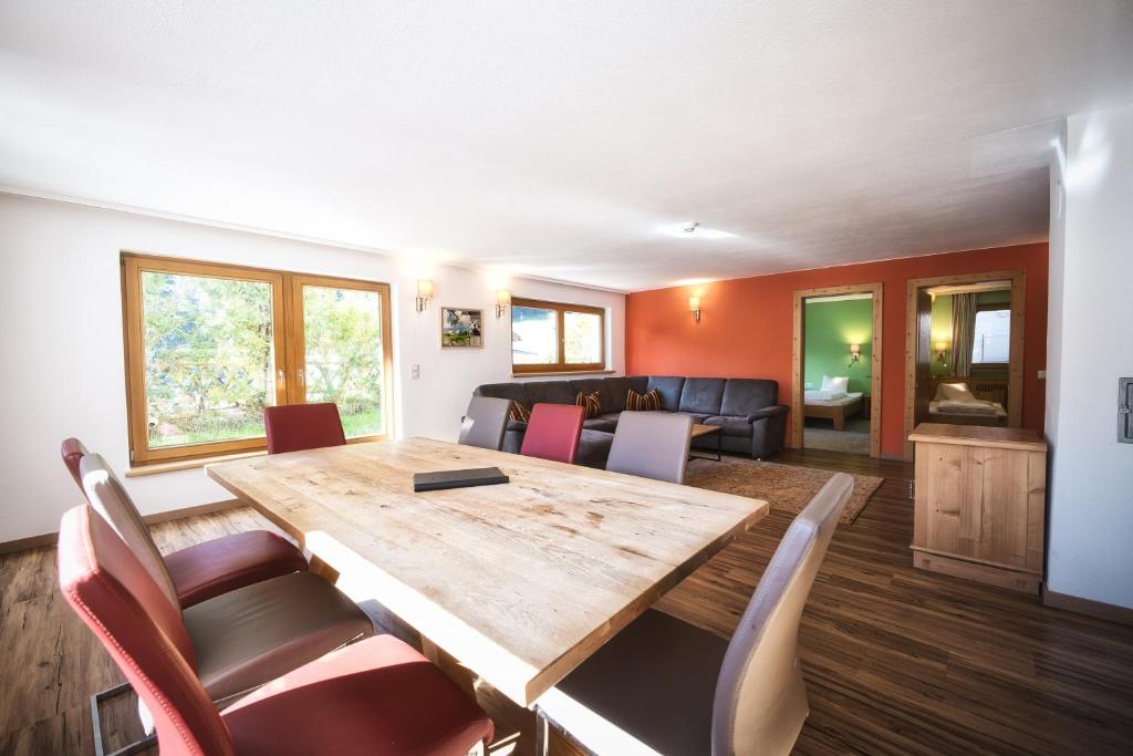 a dining room and living room with a wooden table and chairs at Appartementhaus der Löwe am Arlberg in Flirsch