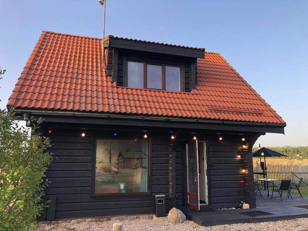 una piccola casa con tetto arancione con finestra di Vanaga namiņš a Sigulda