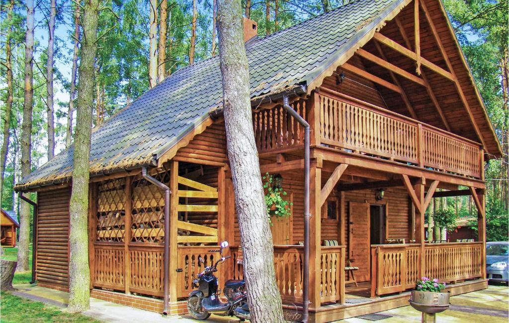 Stunning Home In Ostrda With 2 Bedrooms And Wifi في أوسترودا: كابينة خشب بها دراجة نارية متوقفة أمامه