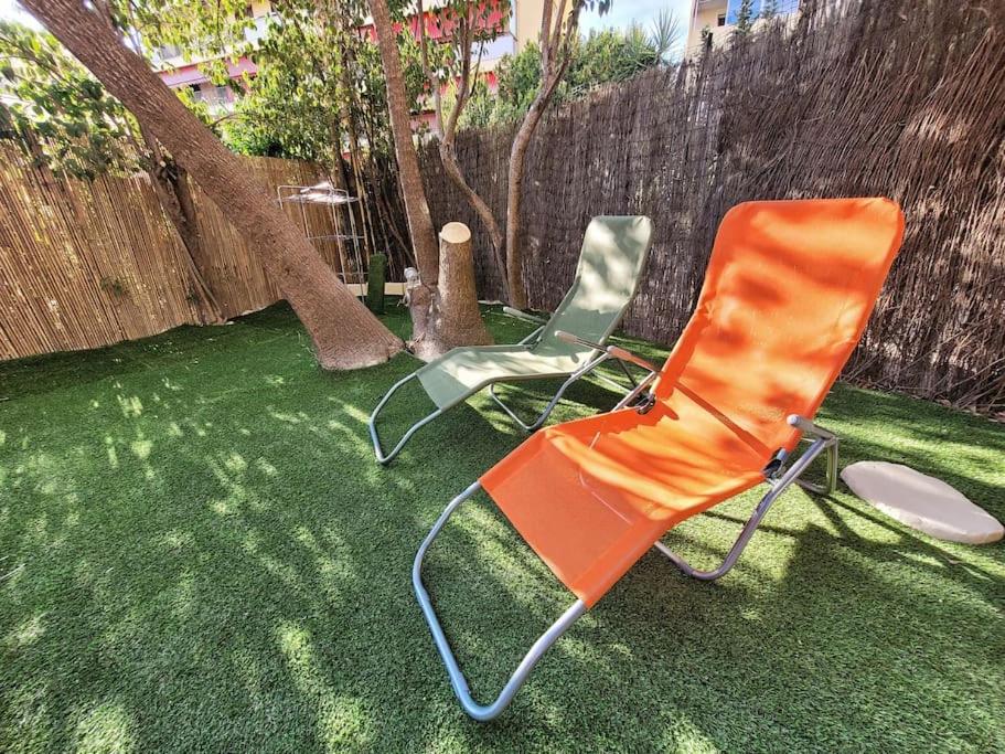 Deux chaises assises sur l'herbe dans une arrière-cour dans l'établissement Parking privé + Jardin + Clim proche Plage & Resto, à Cagnes-sur-Mer
