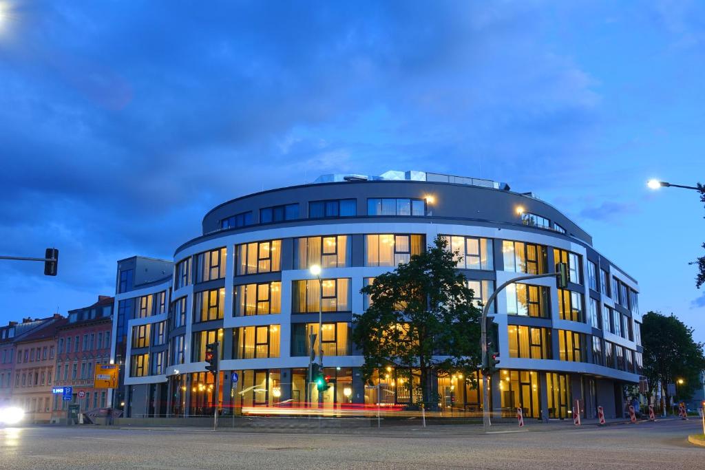 un gran edificio con muchas ventanas en una calle en H24 Stadthotel Bernau en Bernau bei Berlin