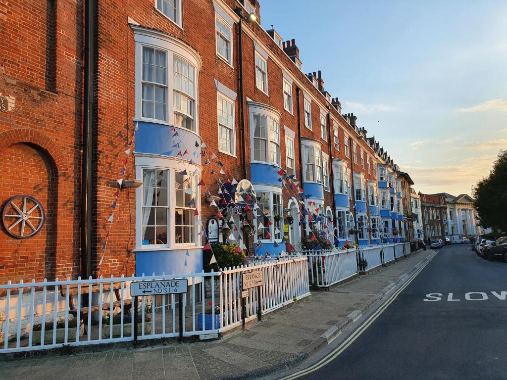 uma fila de edifícios de tijolos numa rua em The Warwick em Weymouth