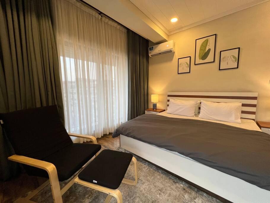 een slaapkamer met een bed, een stoel en een raam bij *Designer’s Luxurious 1BHK at Top Location of Twin Cities!! in Rawalpindi