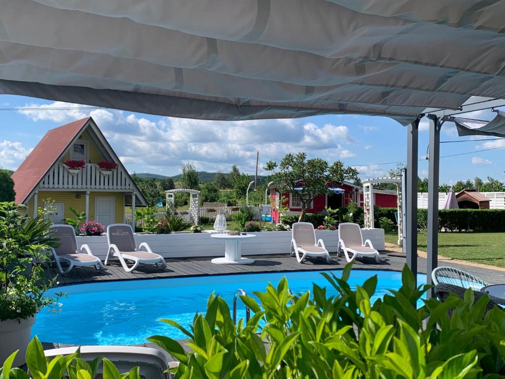 un patio con sillas, una mesa y una piscina en Pool Apartments Plitvice Lakes, en Grabovac