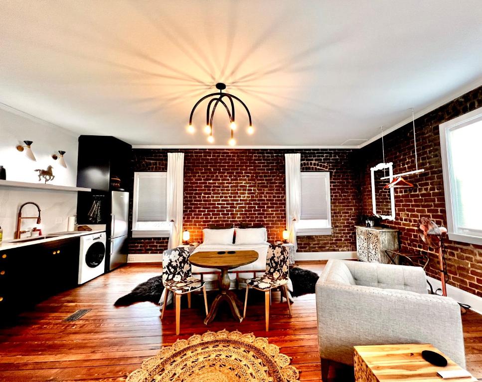 a living room with a table and a brick wall at Be Our Gaston's "The Garden of Good" in Savannah