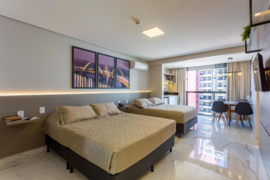 a hotel room with two beds and a dining room at Apart Hotel Centro de Brasília in Brasilia