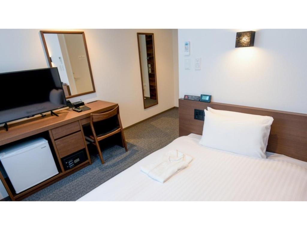 a hotel room with a bed and a flat screen tv at ＹＯＵ ＳＴＹＬＥ ＨＯＴＥＬ ＨＡＫＡＴＡ - Vacation STAY 16012v in Fukuoka