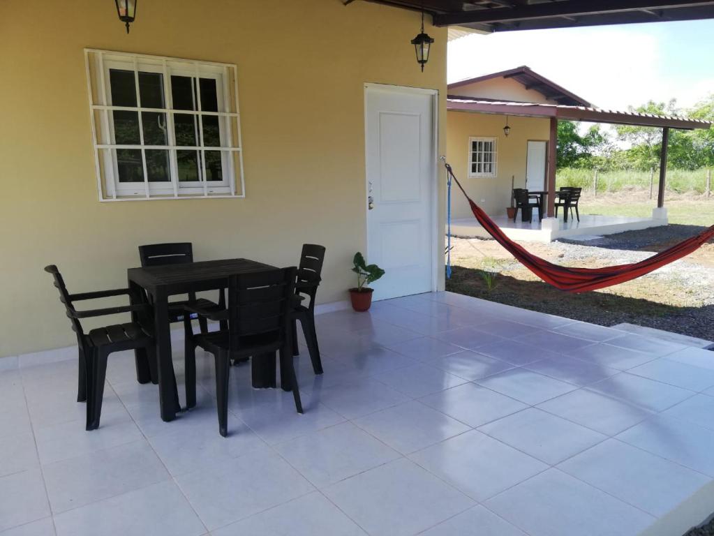 un patio con una mesa negra, sillas y una hamaca en Hostal VILLAS DON PABLO LAS TABLAS en Las Tablas