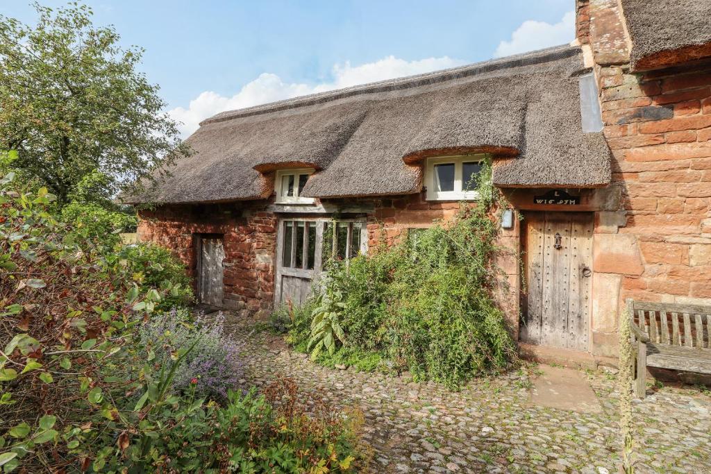 uma antiga casa de pedra com telhado de palha em Ona Ash em Penrith