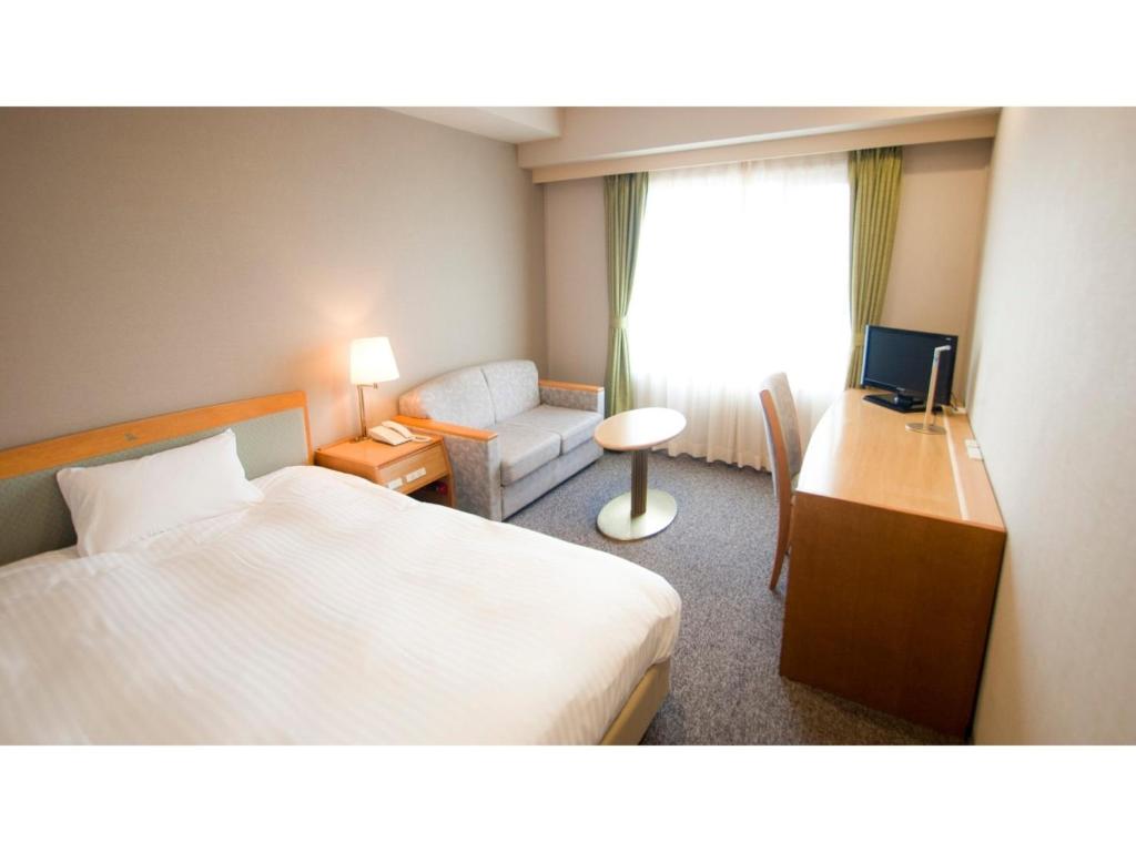 Habitación de hotel con cama, escritorio y sofá en Ako onsen AKO PARK HOTEL - Vacation STAY 21689v, en Ako