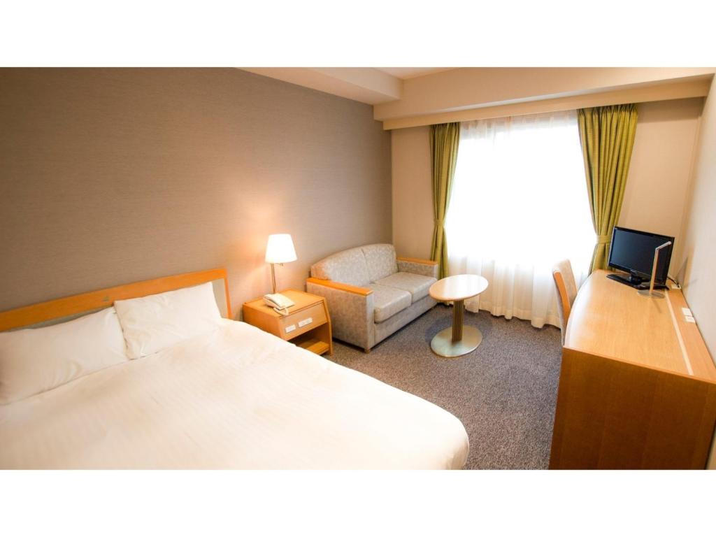 una camera d'albergo con letto, divano e finestra di Ako onsen AKO PARK HOTEL - Vacation STAY 21611v ad Ako