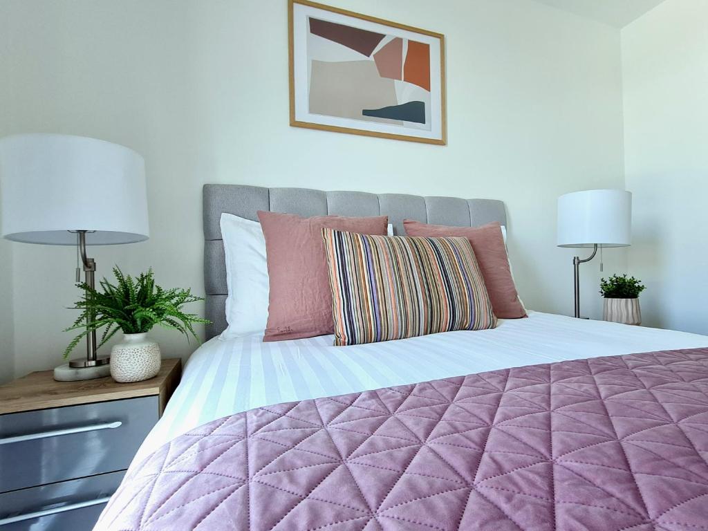 a bedroom with a large bed with a purple comforter at City Centre 2 Bedroomed Apartment - Great views - wifi in Sheffield