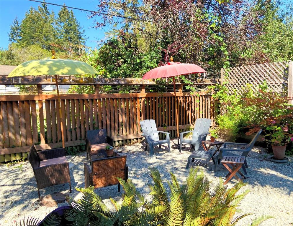 a patio with chairs and tables and umbrellas at Wisteria Guest House in Ganges