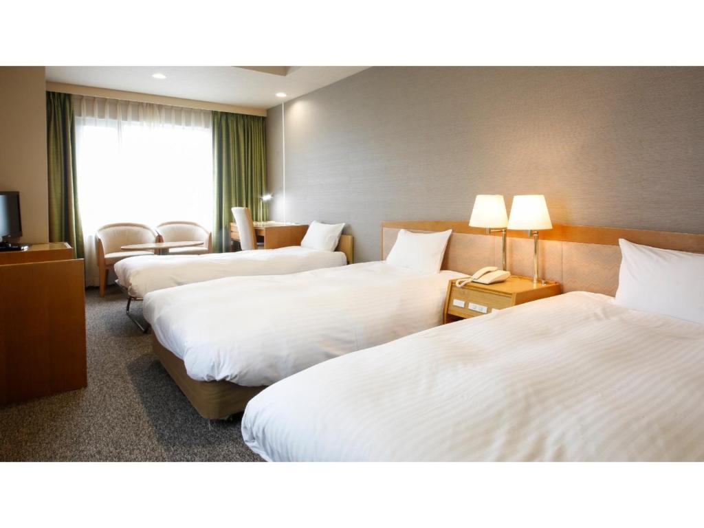 Habitación de hotel con 3 camas y TV en Ako onsen AKO PARK HOTEL - Vacation STAY 21678v, en Ako