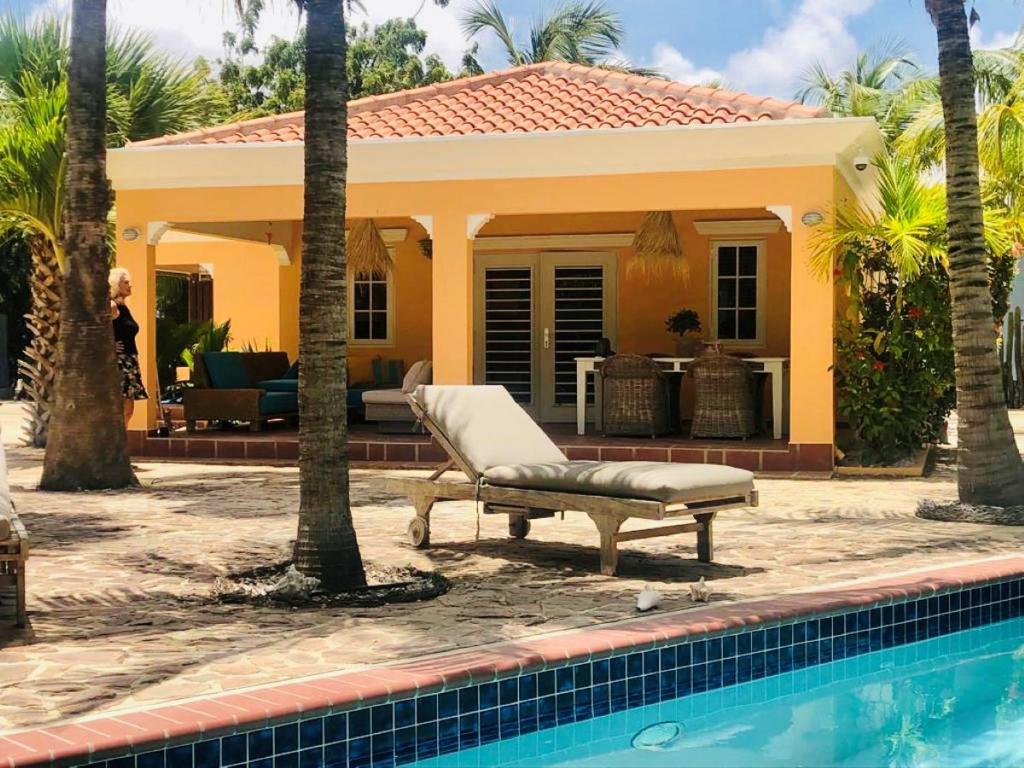 a house with a pool and a chair next to a house at Villa Perla due (diving villa Chikitu) in Kralendijk