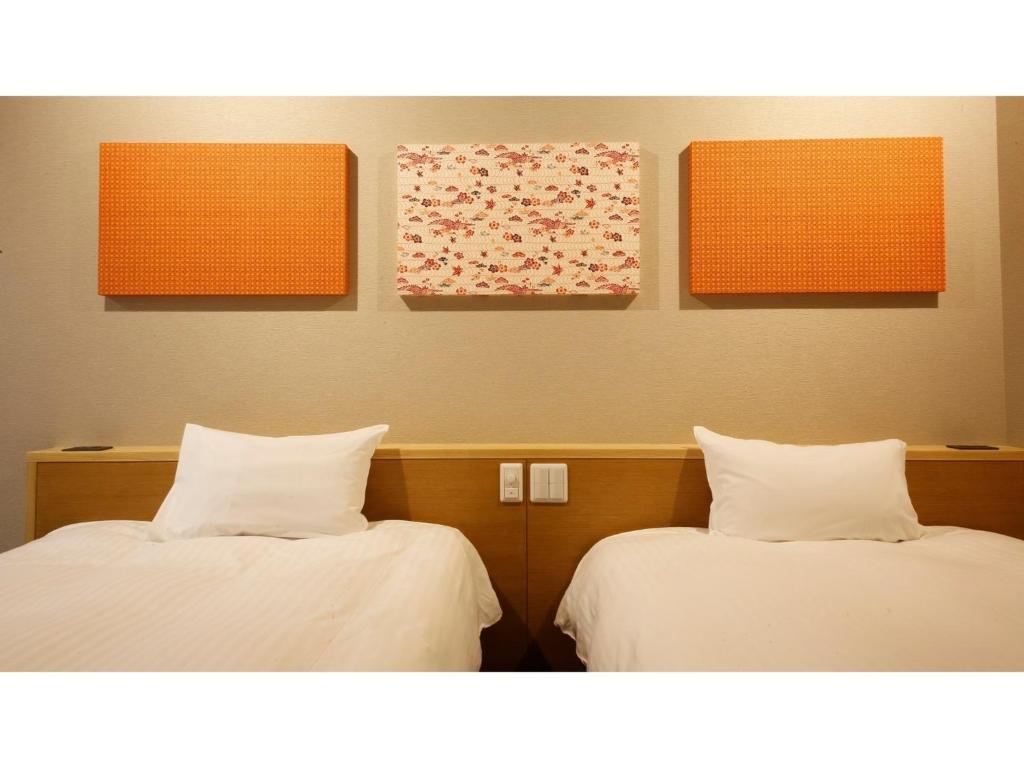 2 camas en una habitación con naranja y blanco en Ako onsen AKO PARK HOTEL - Vacation STAY 21683v, en Ako