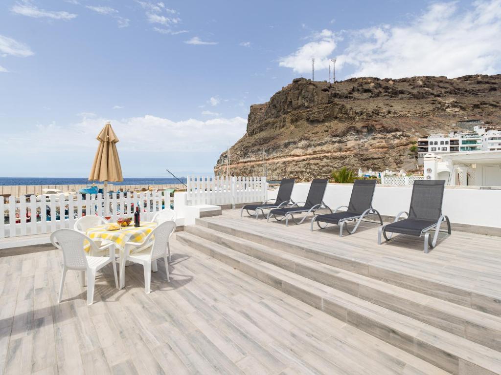 a patio with chairs and a table and the ocean at Marina nº 5 in Puerto de Mogán