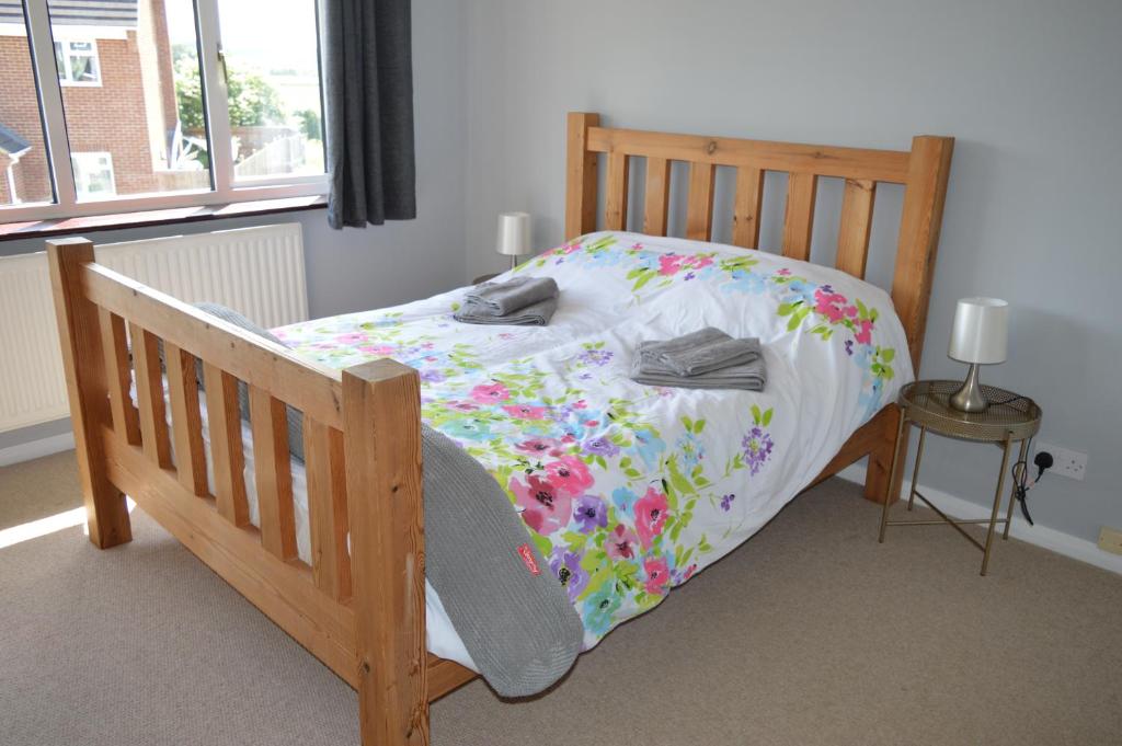 a bedroom with a wooden bed with flowers on it at Cheerful 3 bedroom property set in the countryside in Westcott