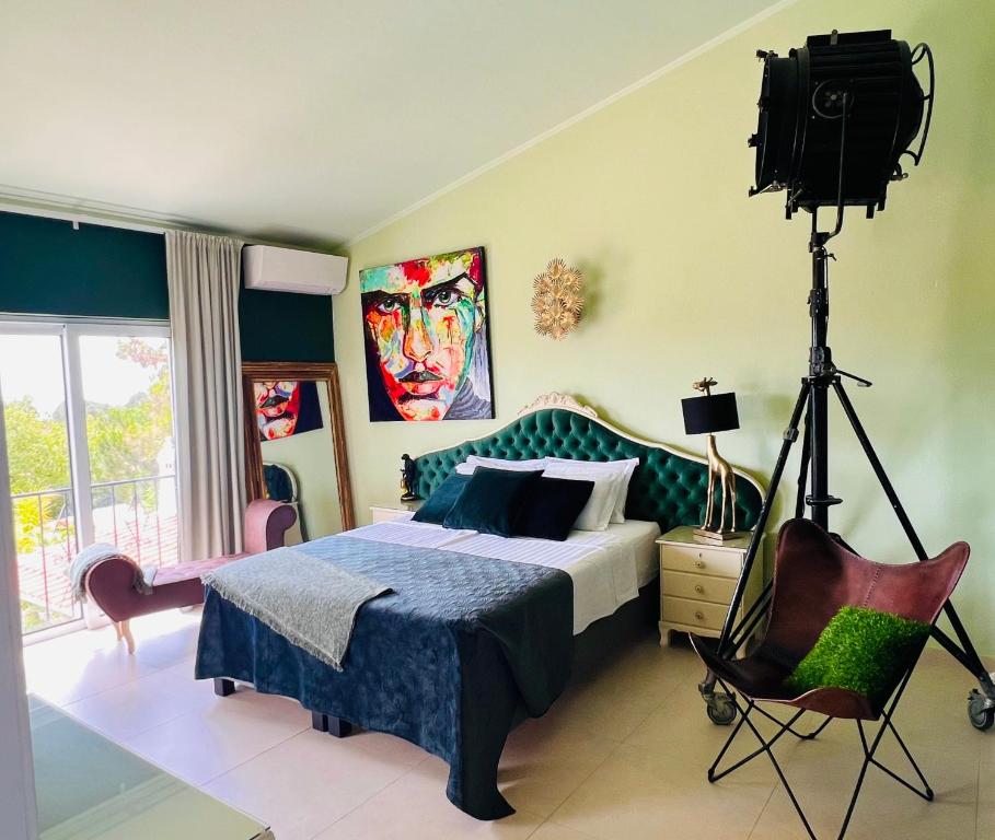 Palm View Guesthouse, adults only في لوز: غرفة نوم بسرير وكاميرا على ثلاثي
