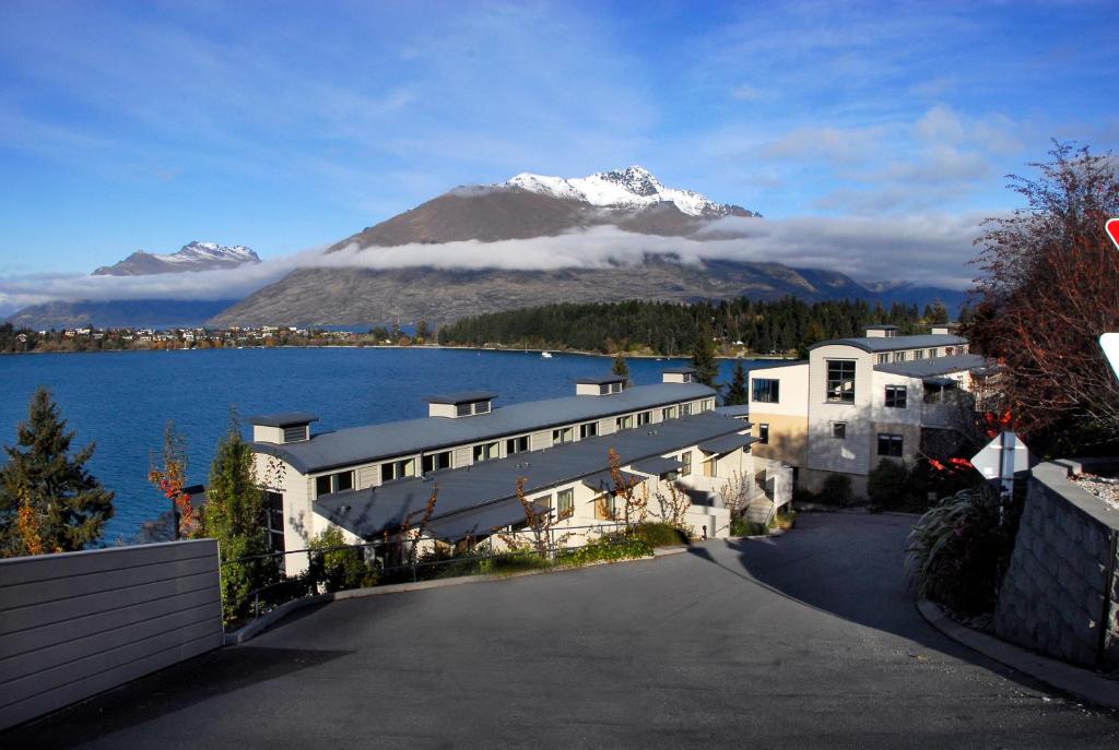 een gebouw met uitzicht op een berg en een meer bij BreakFree The Point in Queenstown