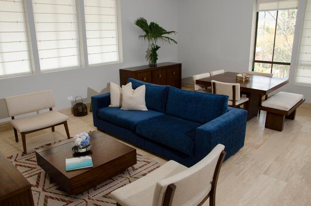 sala de estar con sofá azul y mesa en Paseo Suites El Valle, Luxury Apartments, en El Valle de Antón