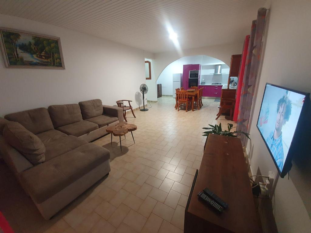 ein Wohnzimmer mit einem Sofa und einem Tisch in der Unterkunft LES 4L Caïmite in Le Carbet