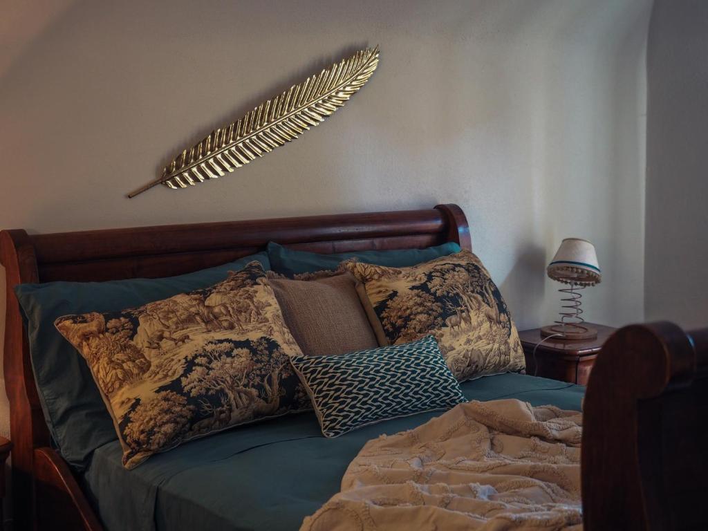 a bed with pillows and a feather on the wall at Locanda del Daino 