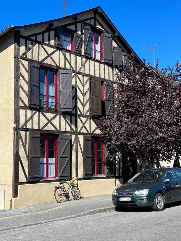 um edifício com uma bicicleta estacionada em frente em Maison de la Calonne - Riverside house & terrace em Cormeilles