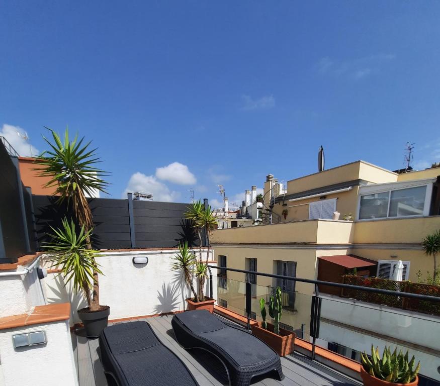 Un balcón con palmeras y un edificio. en Apartaco Apartamentos, en Sitges