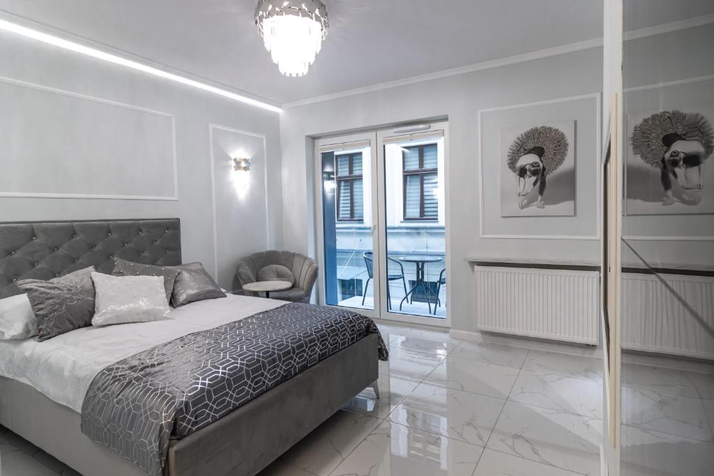 um quarto com uma cama, uma mesa e uma janela em Apartament LUNA, Piotrkowska 44 - free parking em Lódź