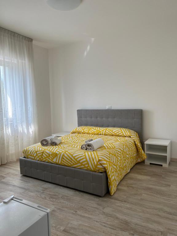 sypialnia z dużym łóżkiem i żółtym kocem w obiekcie Maison Merci w mieście Pedemonte