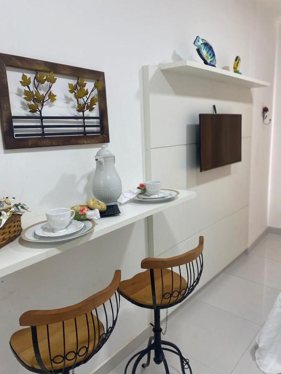 a room with two chairs and a table with a mirror at Flat Bervely Hills 308 in Vila Velha