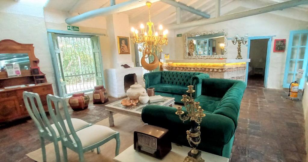 sala de estar con sofá verde y sillas en Casa Provenzal, en Villa de Leyva