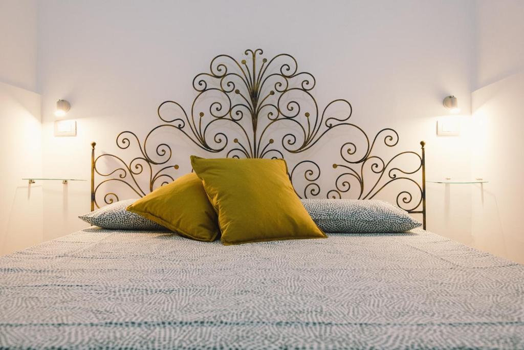 een bed met twee gele kussens erop bij Casa Grazia Guest House in Aci Castello